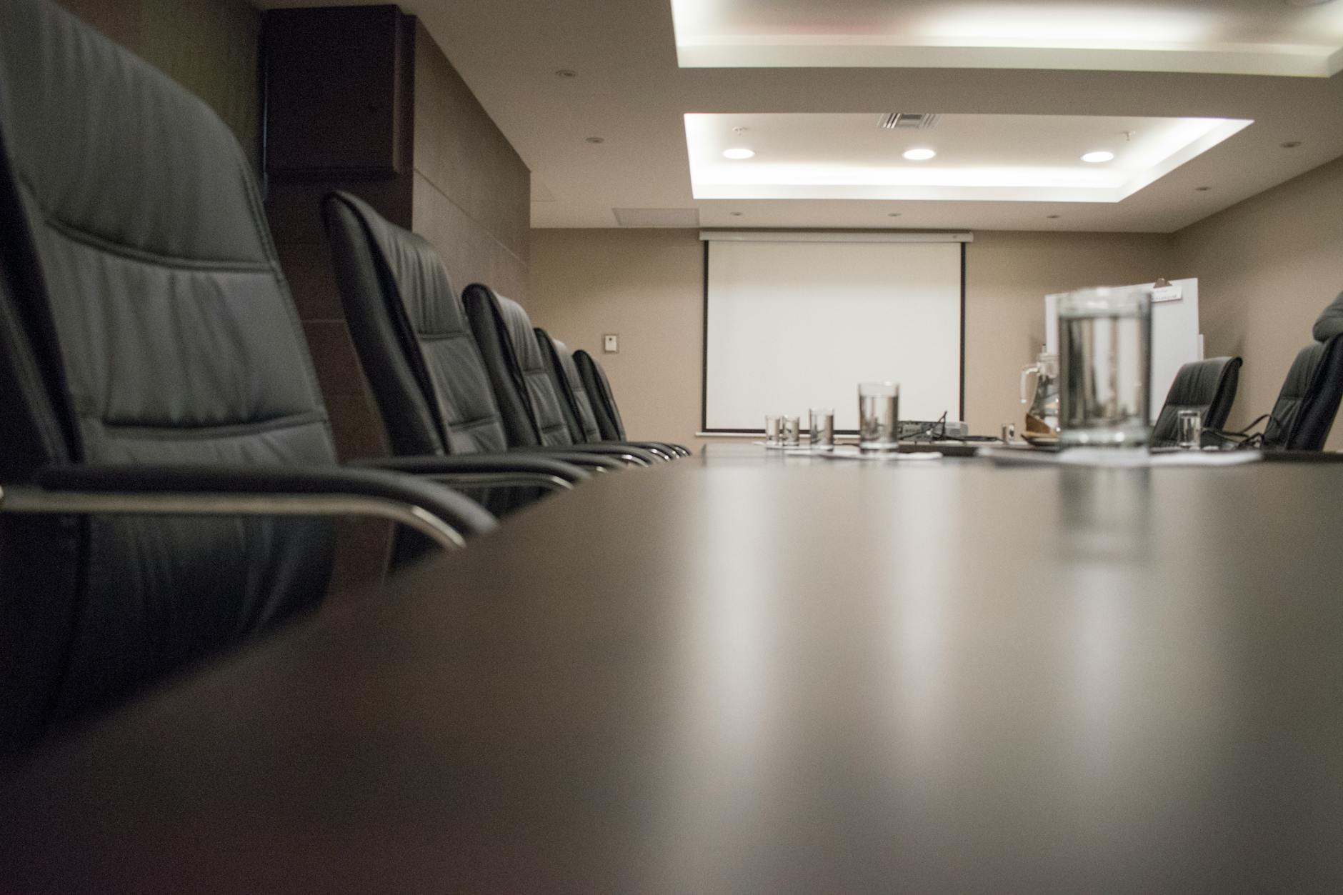 Empty corporate boardroom with chairs around conference table