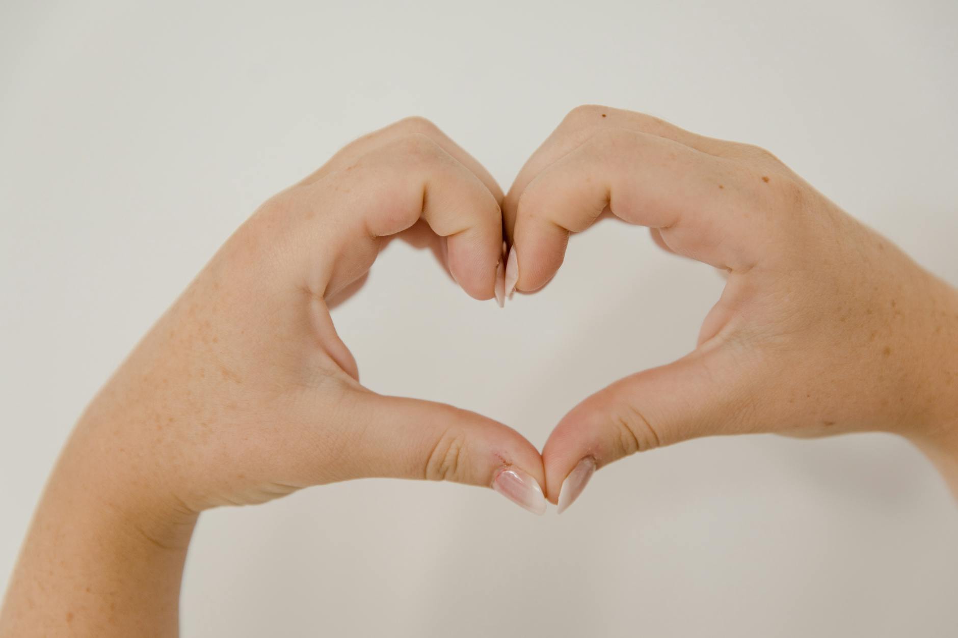 Hands forming heart shape symbolizing emotional vulnerability and connection