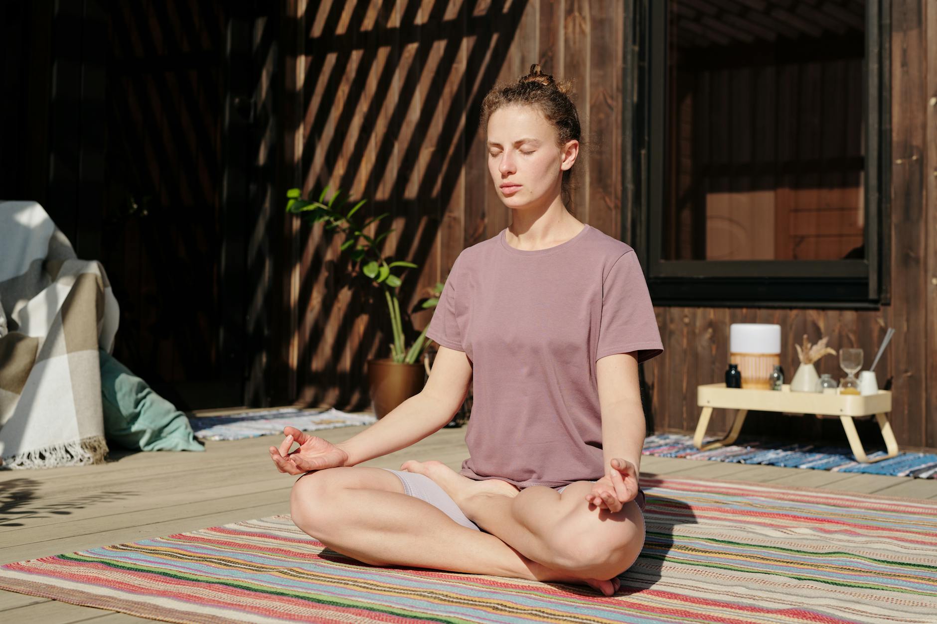 Woman sitting in meditation pose outdoors during golden hour