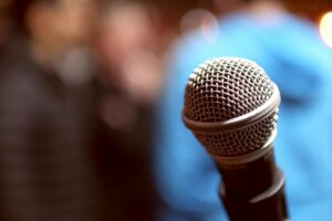 Stand-up comedy stage with microphone under spotlight in dark venue