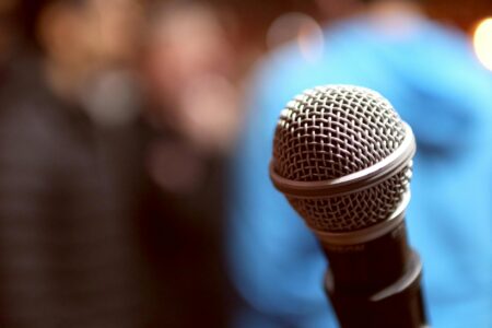 Stand-up comedy stage with microphone under spotlight in dark venue