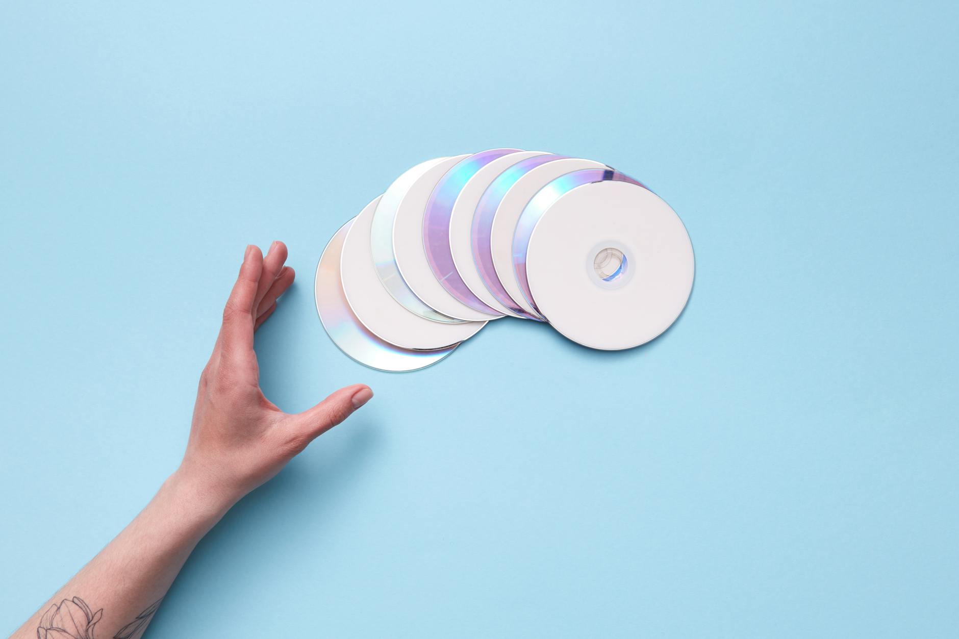 Stack of colorful music CDs arranged on a wooden surface
