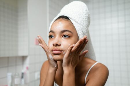 Woman washing her face with cleanser at bathroom sink