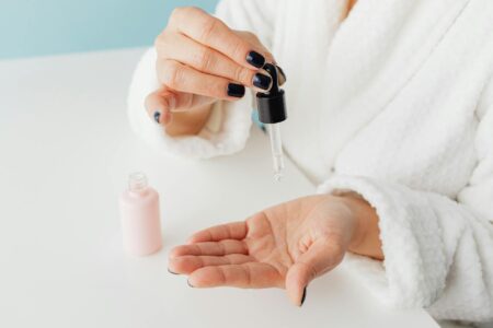 Person applying facial serum with dropper