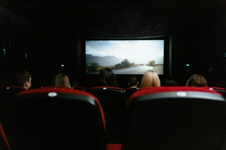 Audience watching movie in theater showing excitement and anticipation