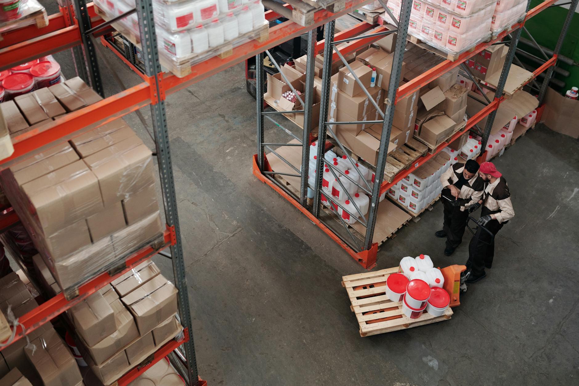 Workers in industrial warehouse setting wearing safety gear