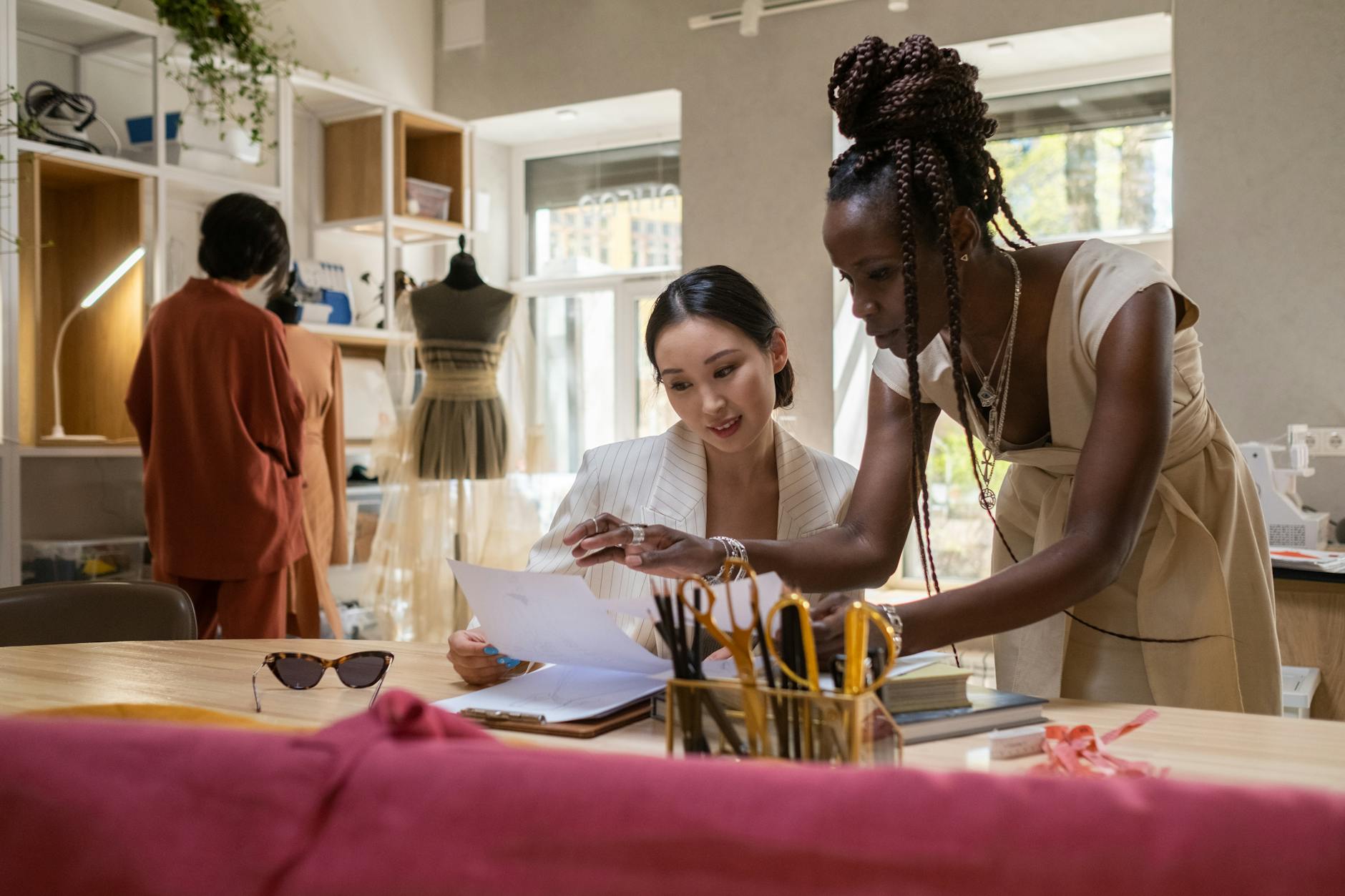 Creative professionals collaborating on fashion project in modern workspace setting
