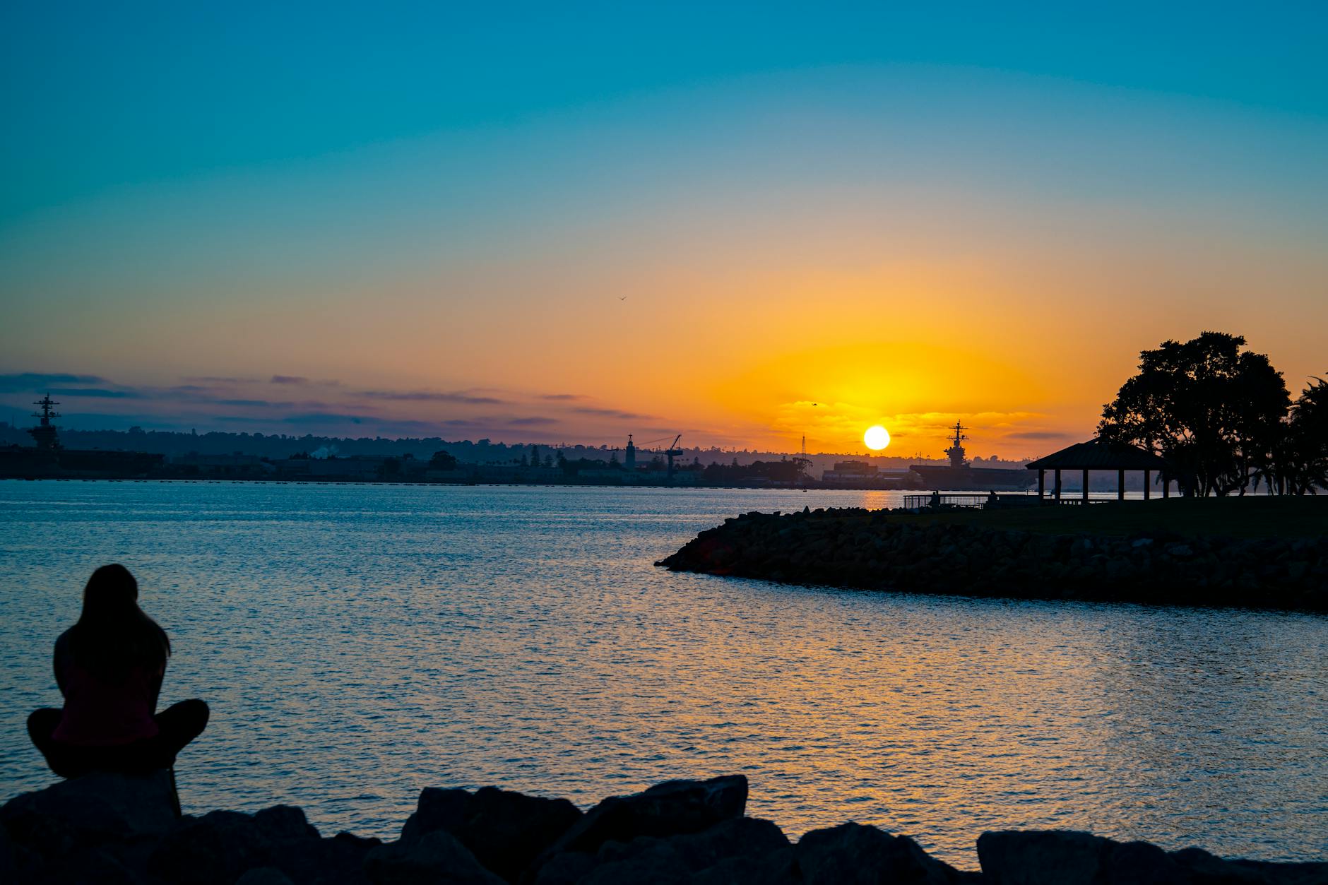 Person meditating in silhouette against twilight sky