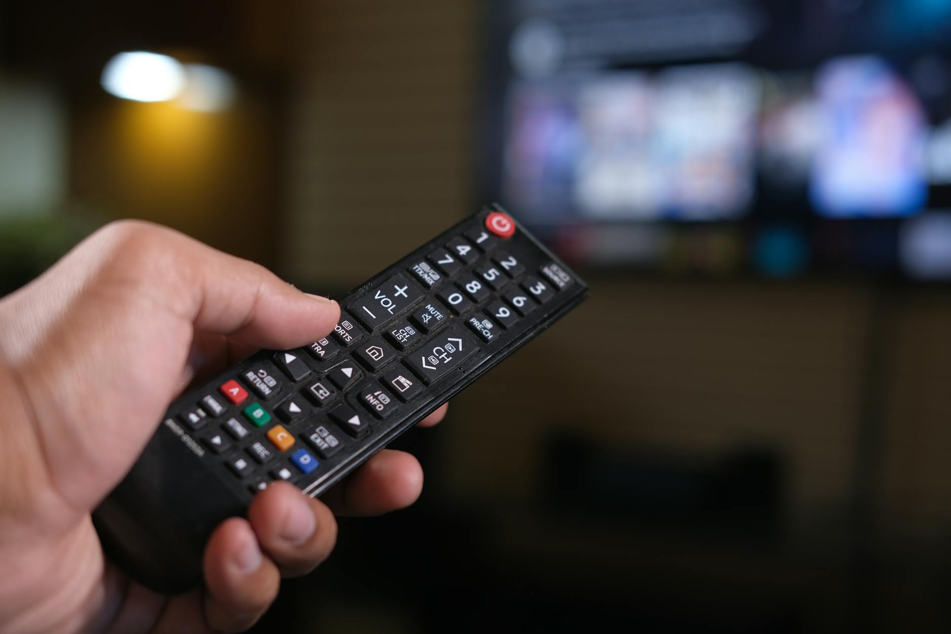 Stack of books next to television remote control