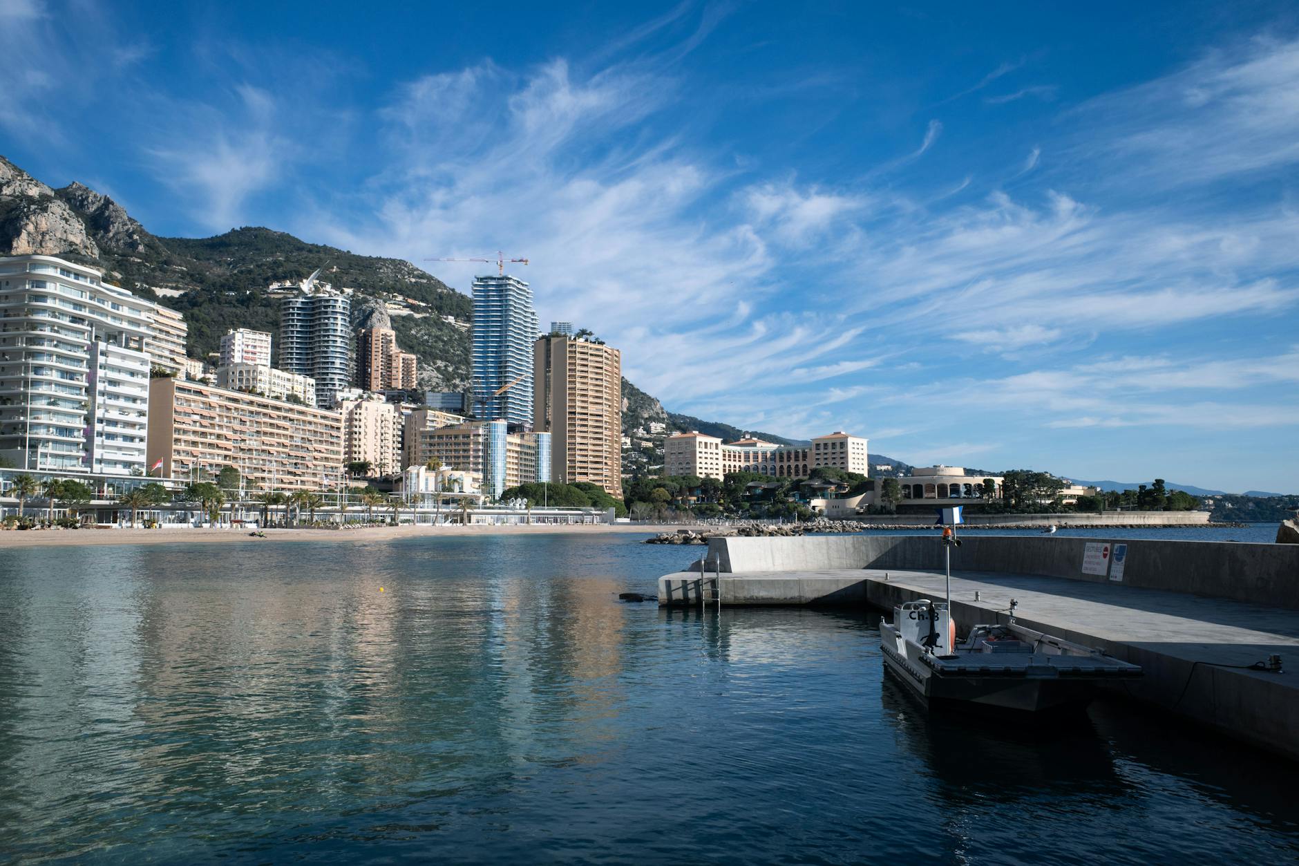 Luxury yachts docked along the Monaco waterfront on a clear day
