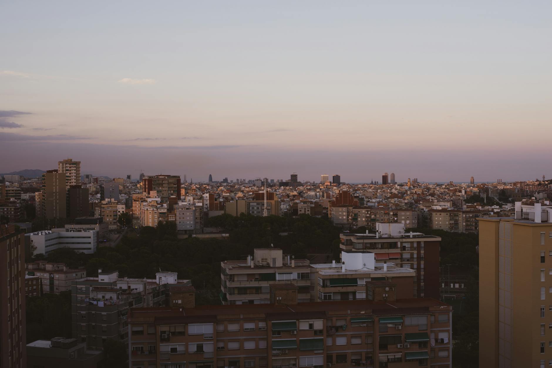 Two people dressed for a summer evening on an urban rooftop with city lights behind them