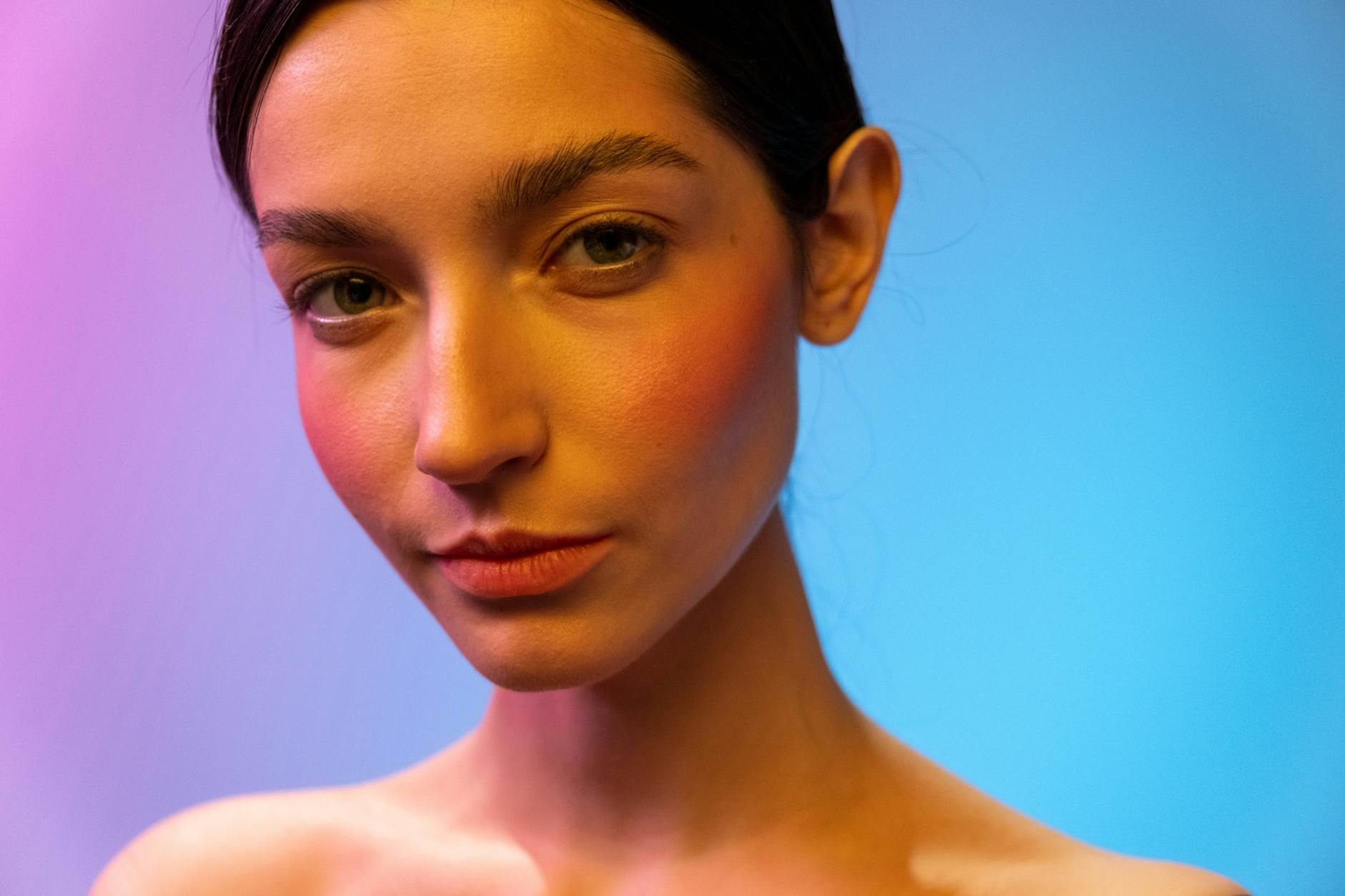 Woman in her thirties with clear glowing skin looking away from camera in natural light