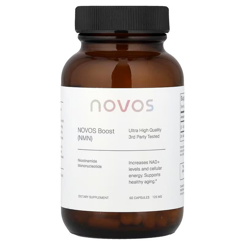 Close-up of supplement capsules spilling from a white bottle on a marble surface