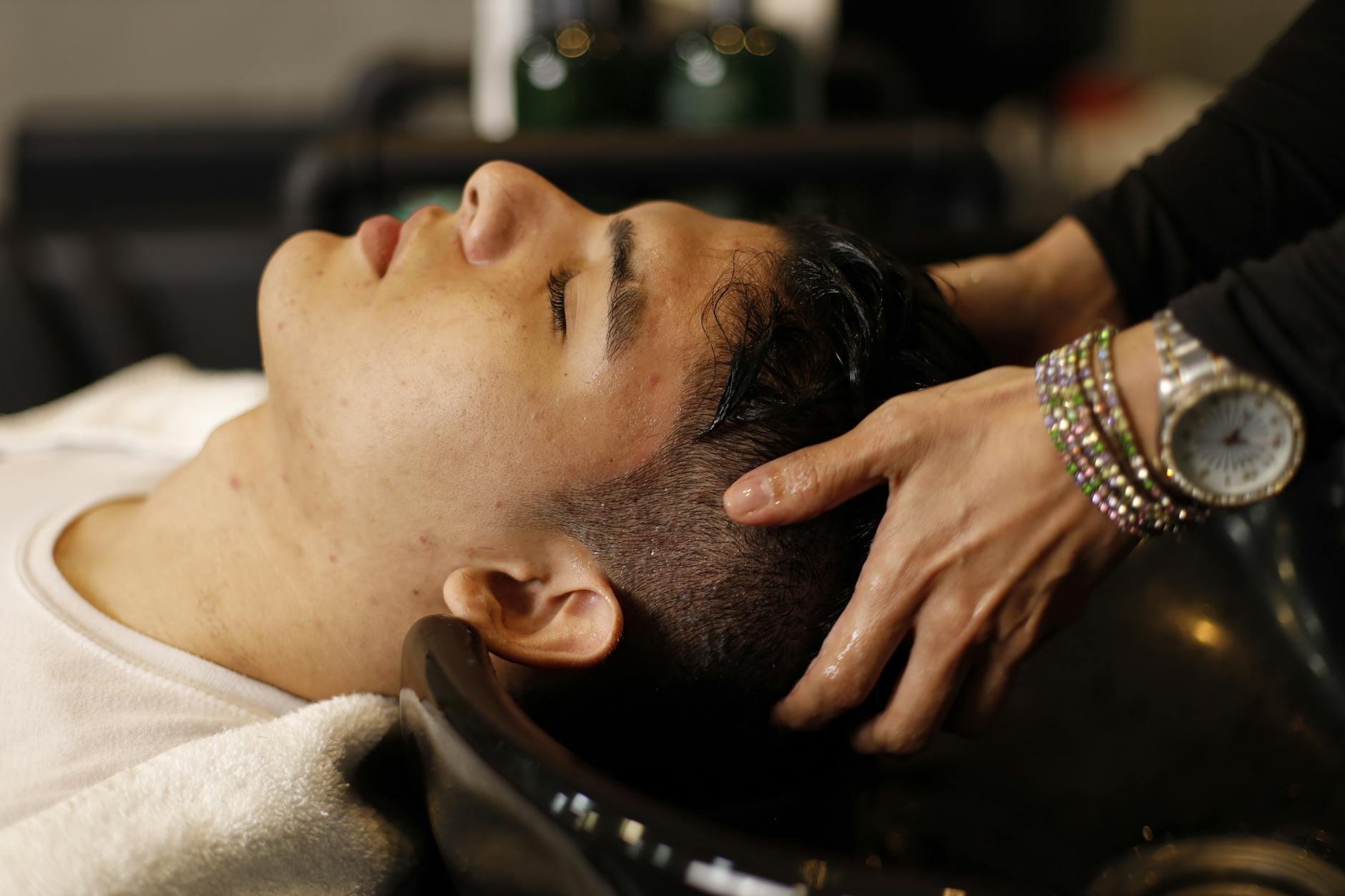 Person applying serum to scalp with dropper applicator