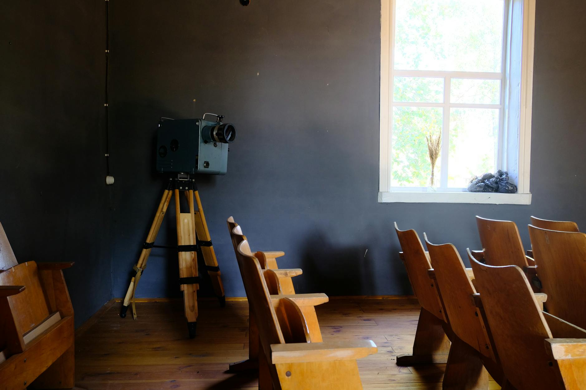 A vintage film projector casting light in a darkened screening room