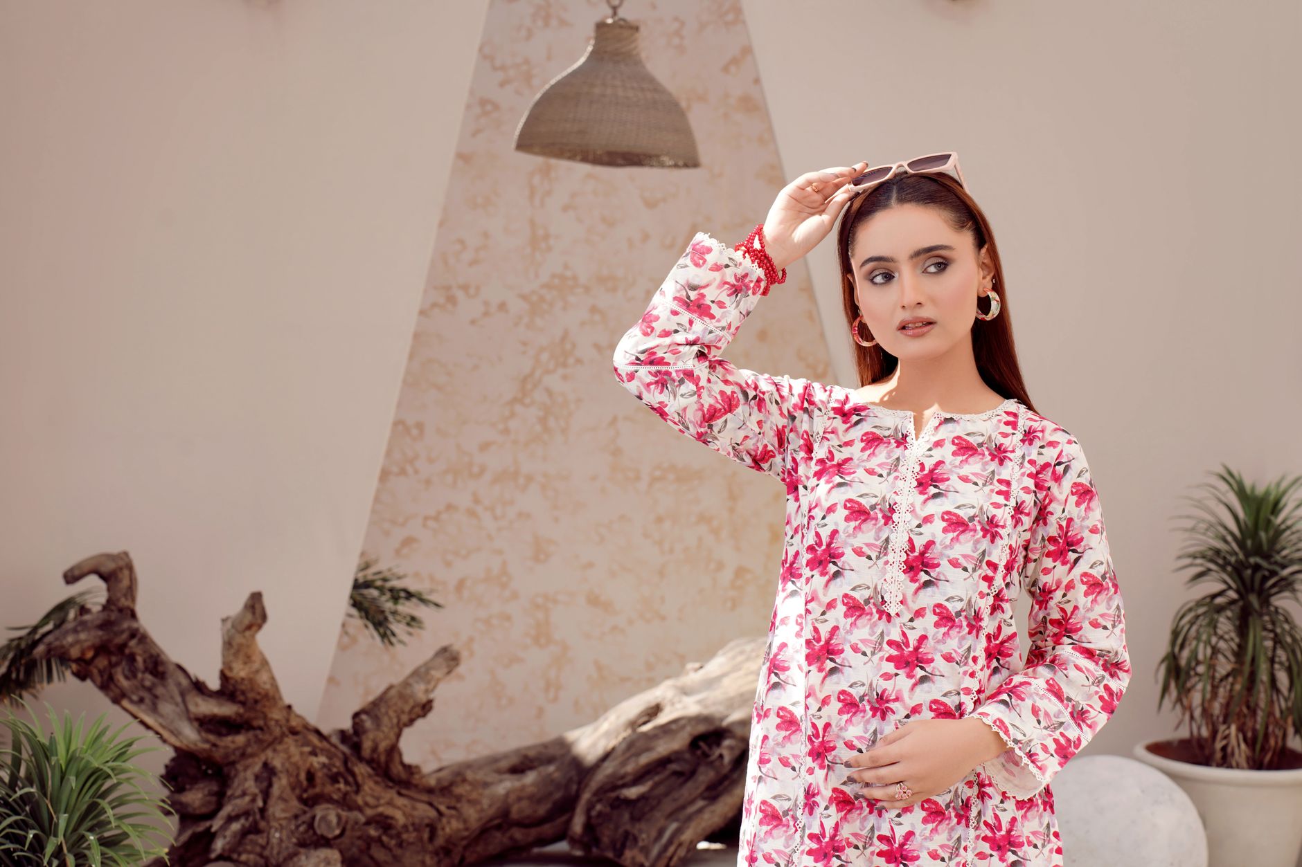 Woman wearing a patterned silk top with draped fabric detail in summer setting