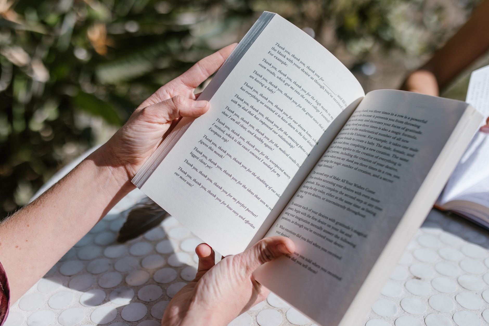 A paperback novel open on a table with soft natural light falling across the pages