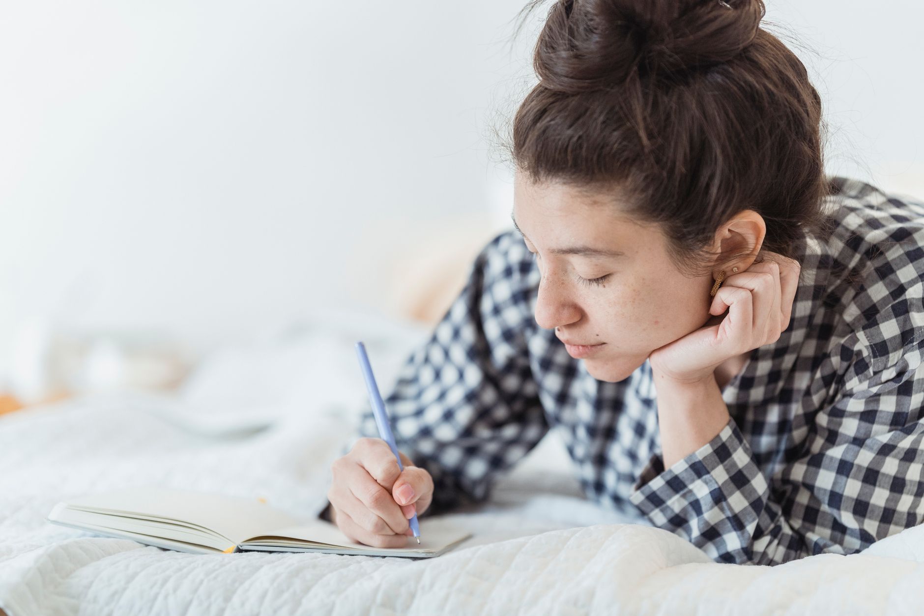Woman sitting quietly writing in a journal, reflecting on personal decisions