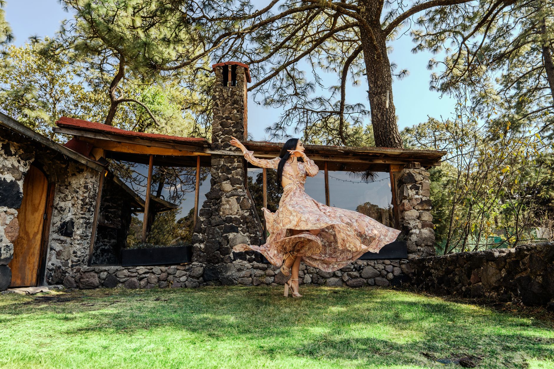 Woman dancing freely in an outdoor natural setting during summer