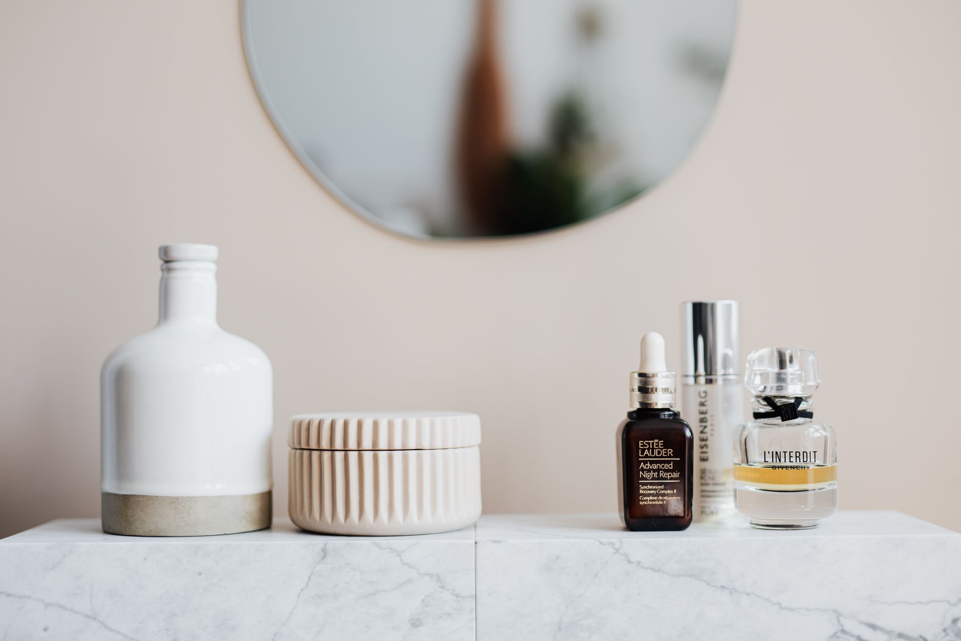 Woman applying skincare product at a bathroom mirror