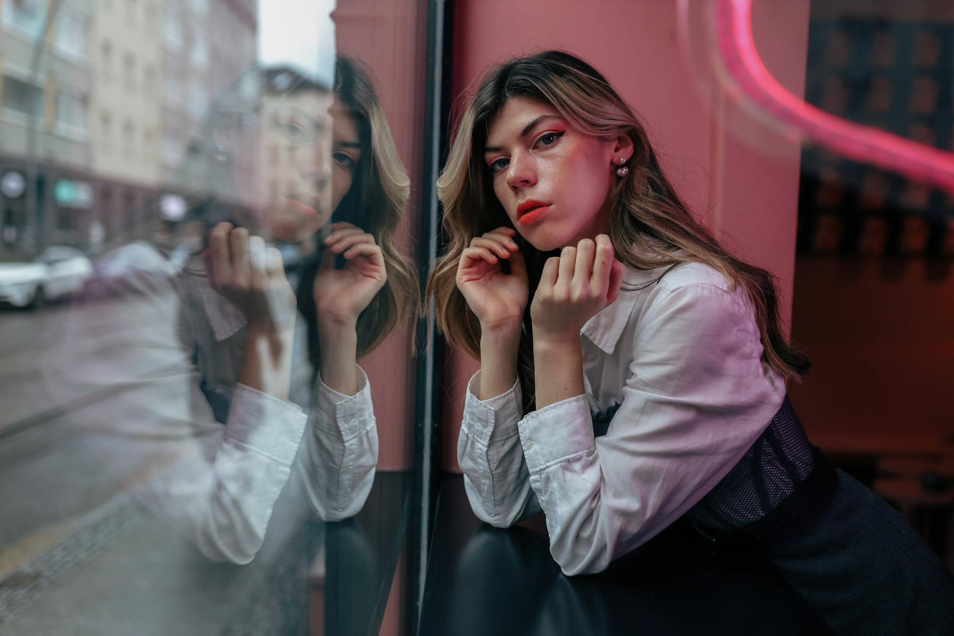 A woman standing near a window in quiet contemplation