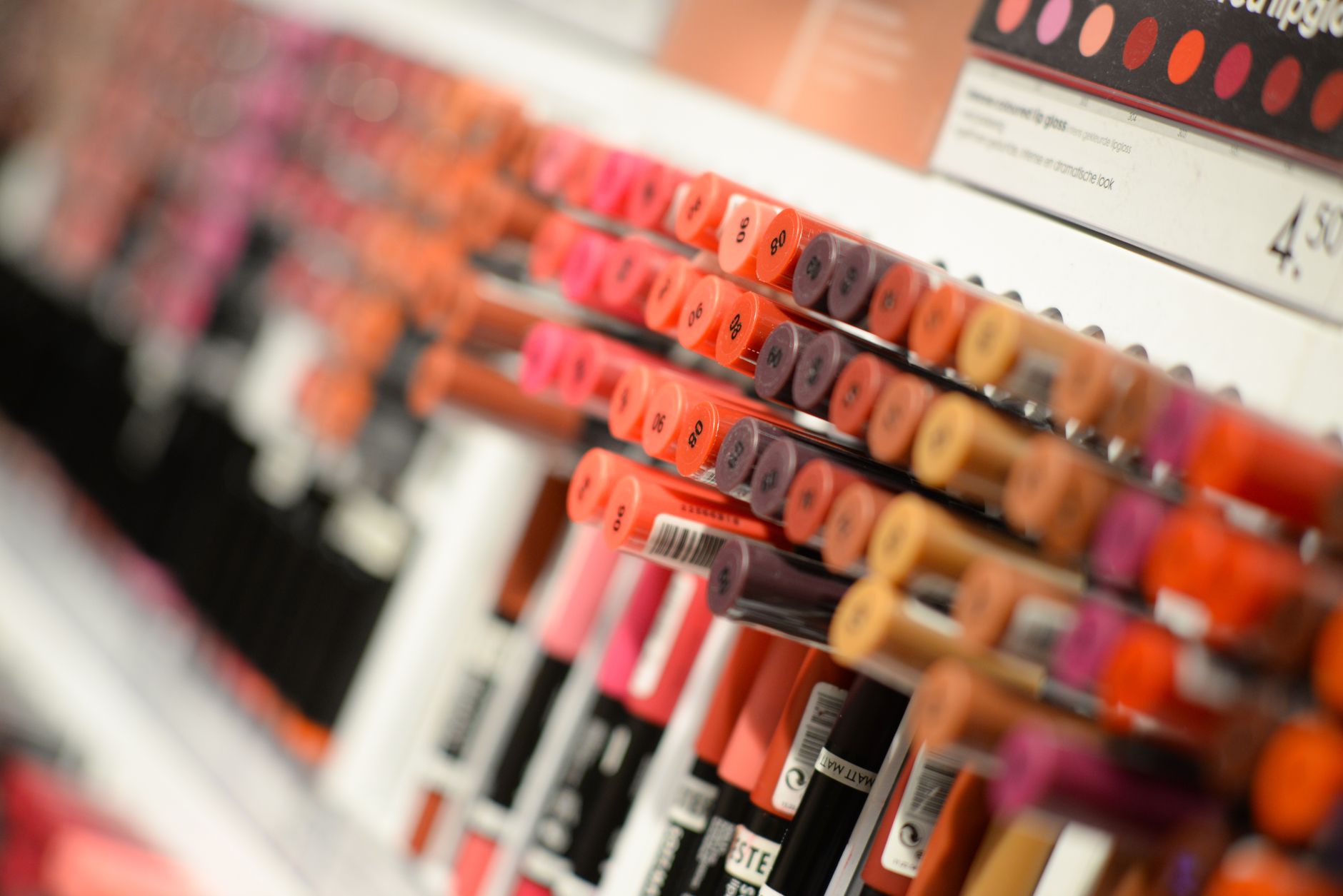 Assorted makeup products arranged on a light surface in warm summer lighting