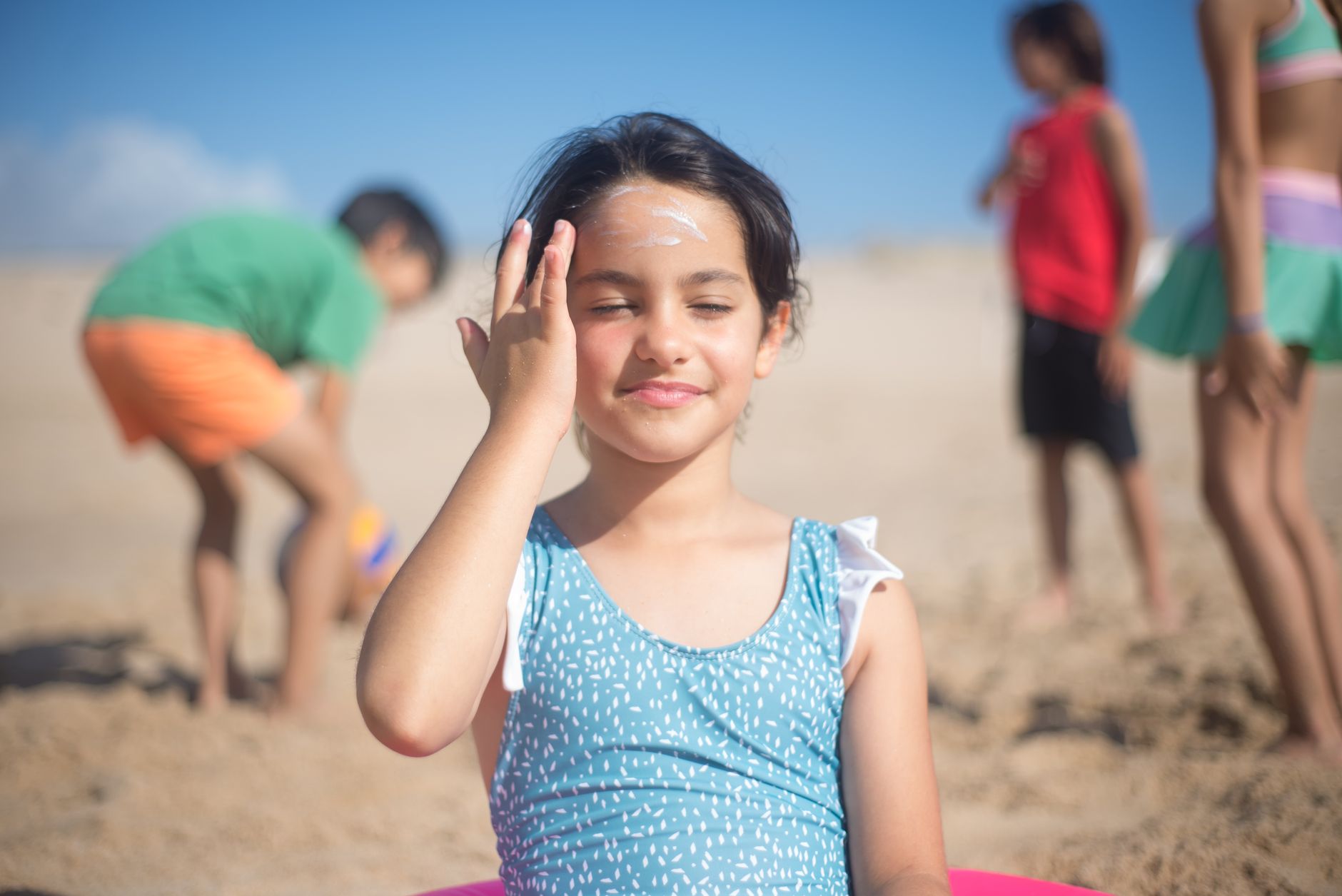 Person applying lightweight sunscreen to their face in natural daylight