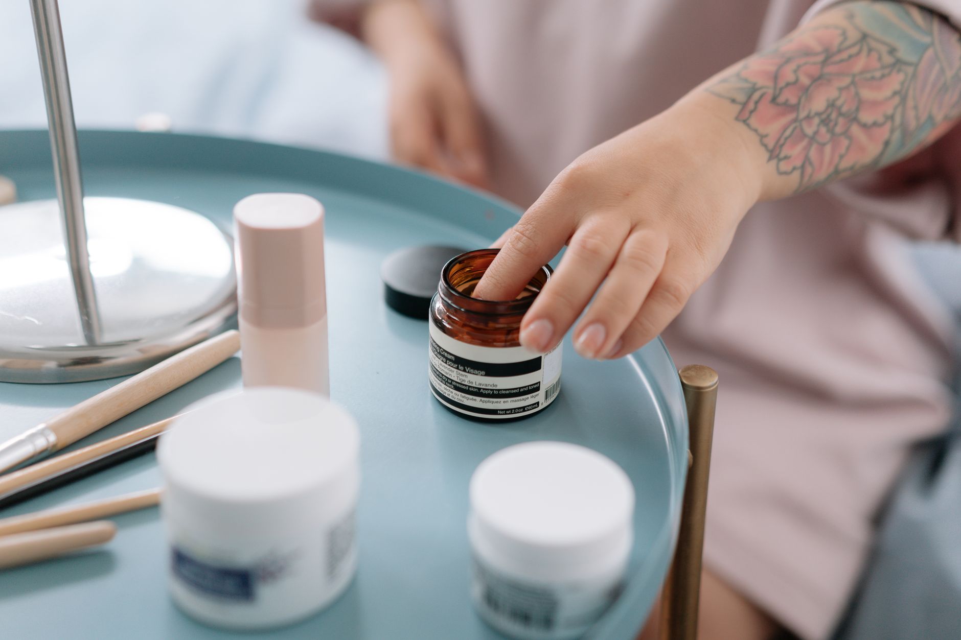 Skincare products laid out on a bathroom shelf with soft lighting