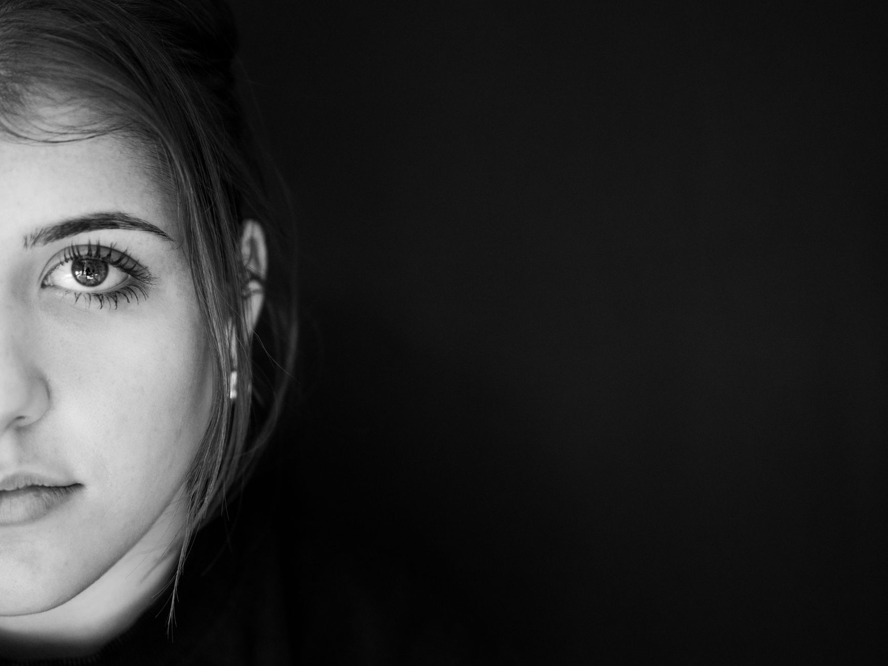 Close-up portrait of a young woman with natural lighting highlighting facial features