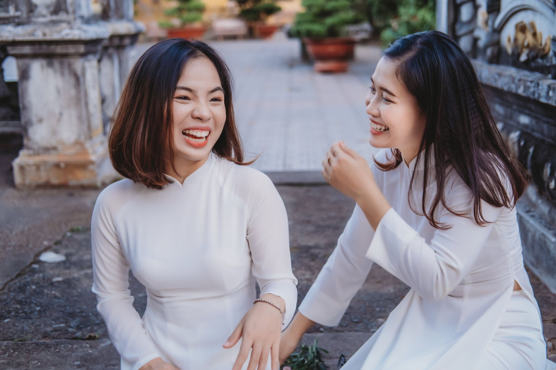 Two young women laughing together outdoors, capturing a close sisterly bond
