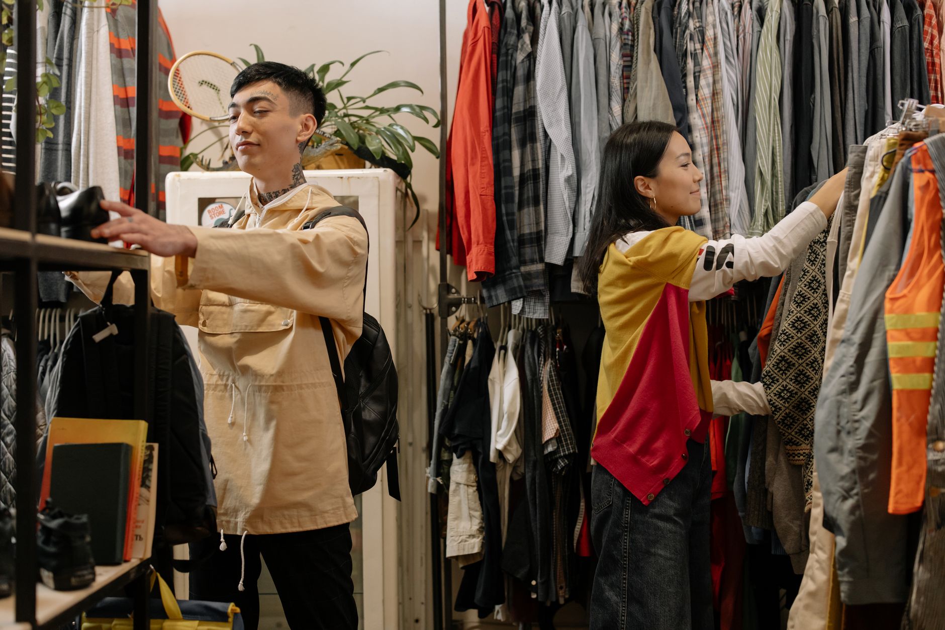 Person browsing through secondhand clothes at a thrift shop