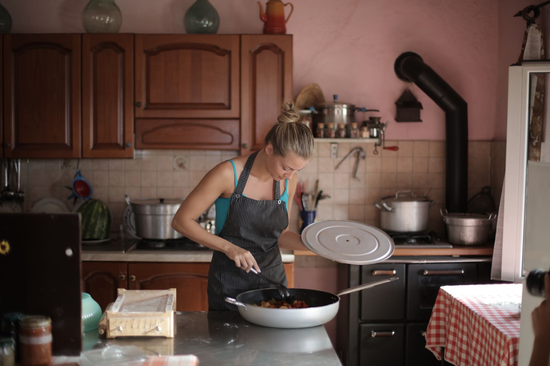 A woman standing at a kitchen counter preparing food in a quiet domestic setting