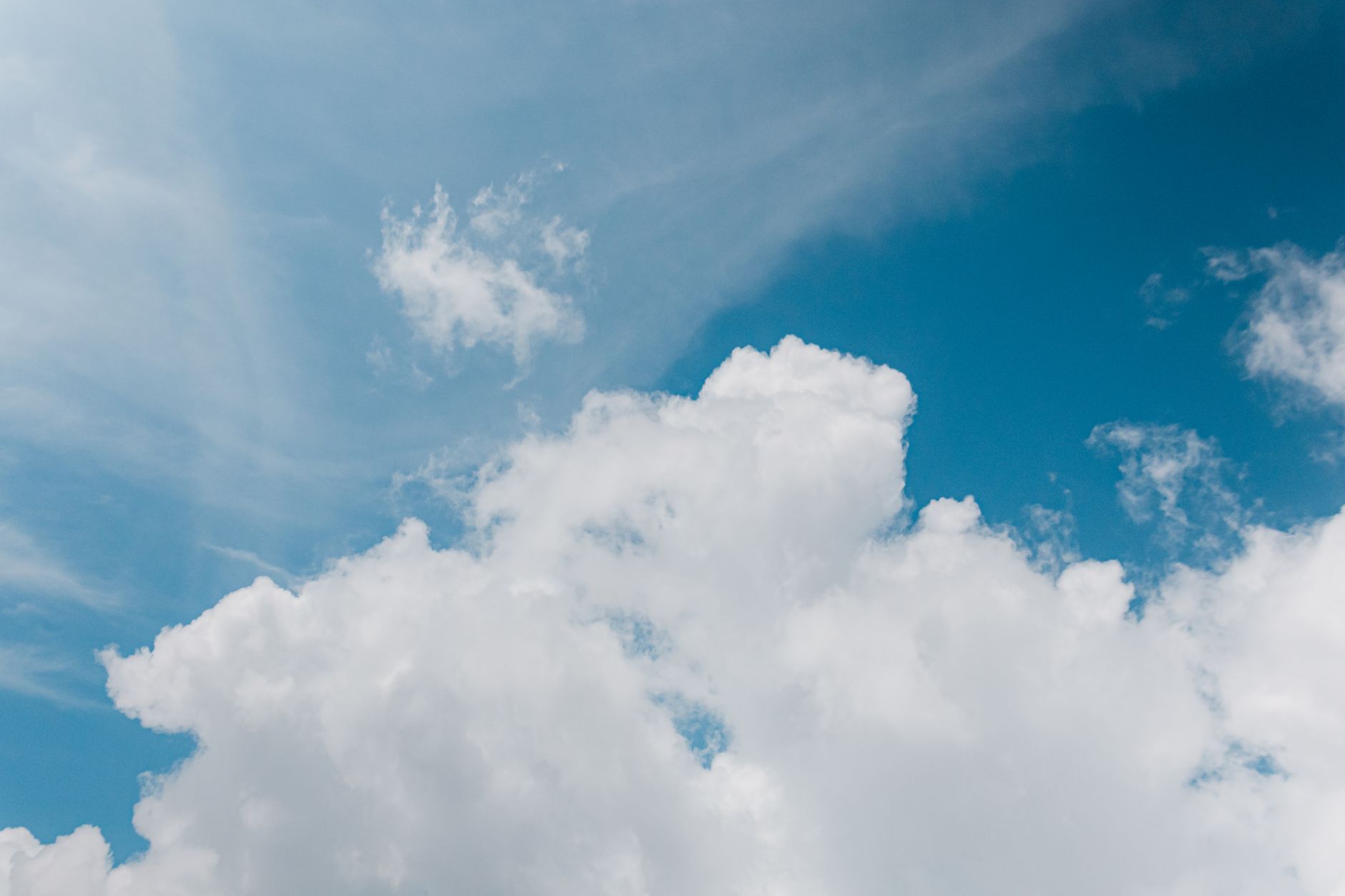 Bright July sky with soft clouds, wide open horizon