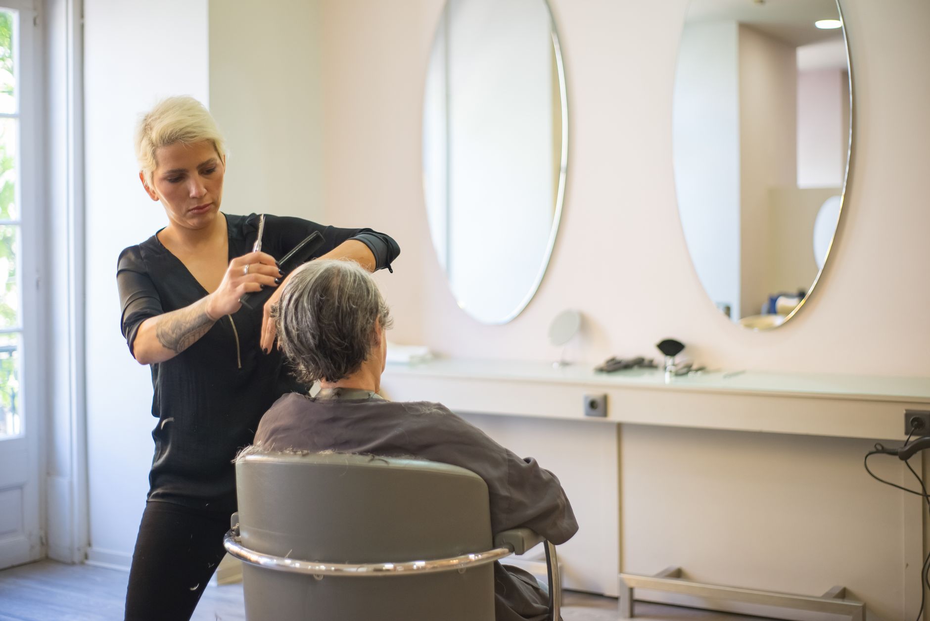 Woman examining her hair in a mirror after a salon appointment
