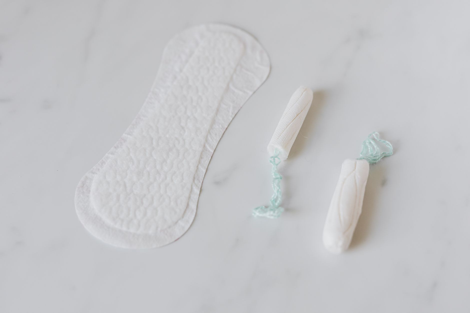 Clean, minimalist feminine hygiene and wellness products arranged on a white background