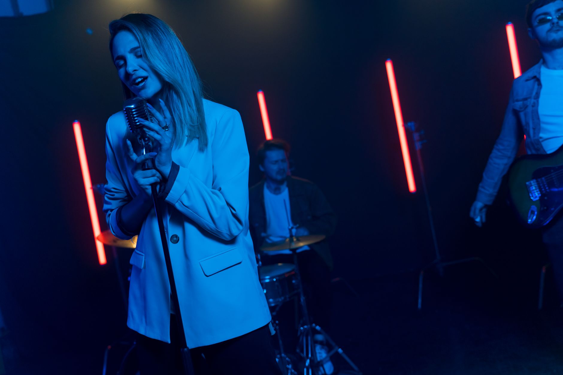 A musician performing on a dimly lit stage with a microphone