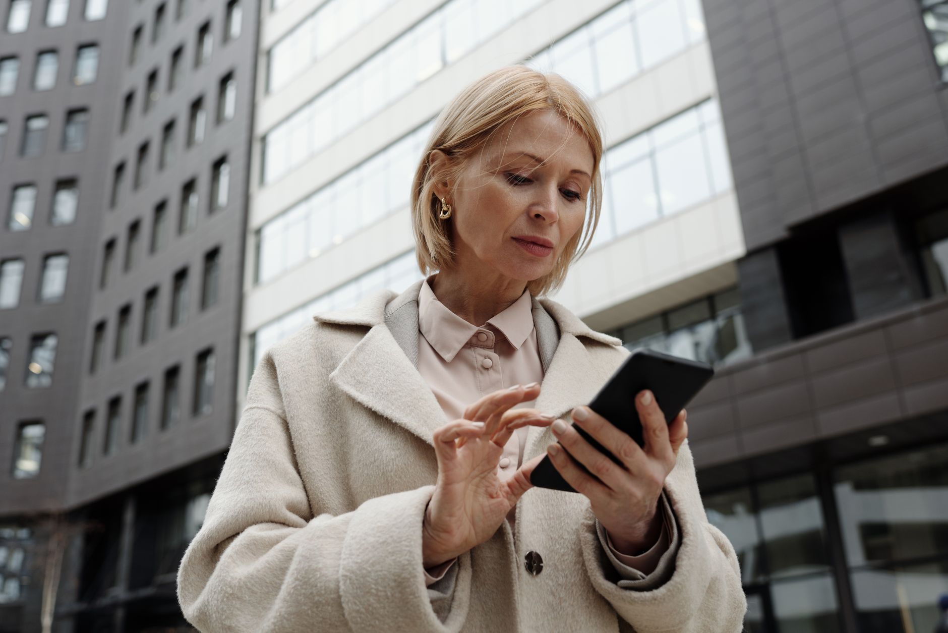 A woman checking her phone with a neutral expression in a modern interior