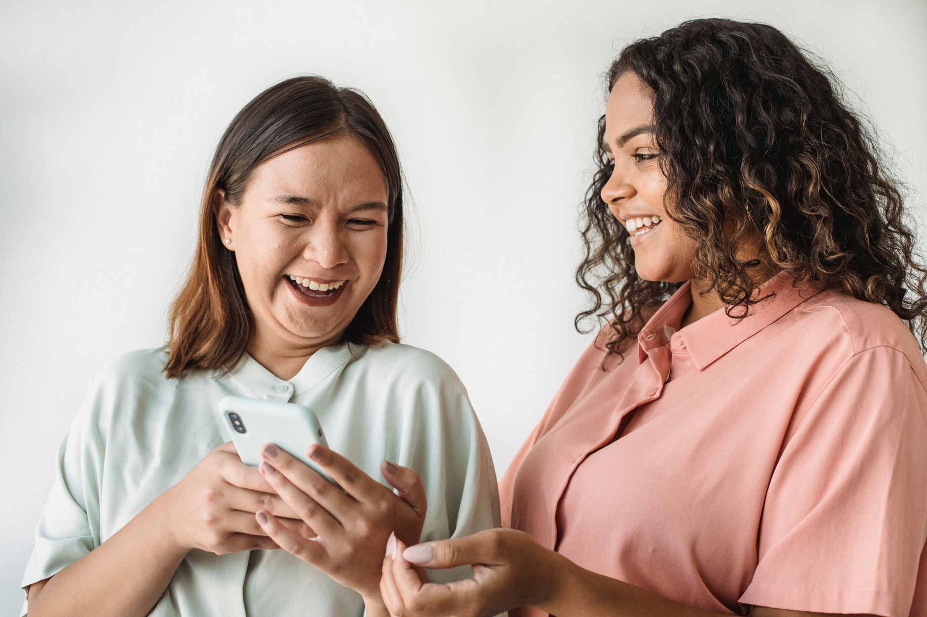 Two young women standing together, smiling, representing female friendship and connection