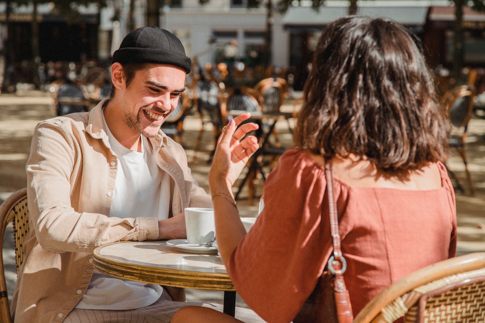 Two people sitting across from each other at a cafe on a first date