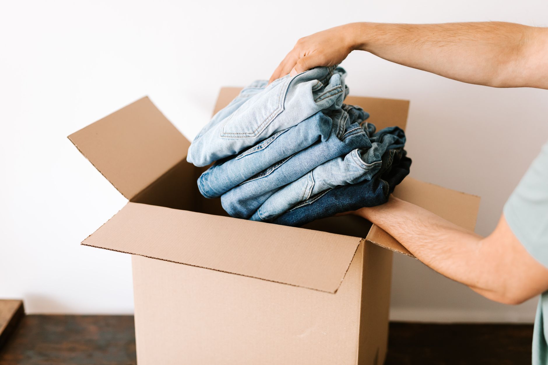 Neatly folded clothing being packed into a travel bag