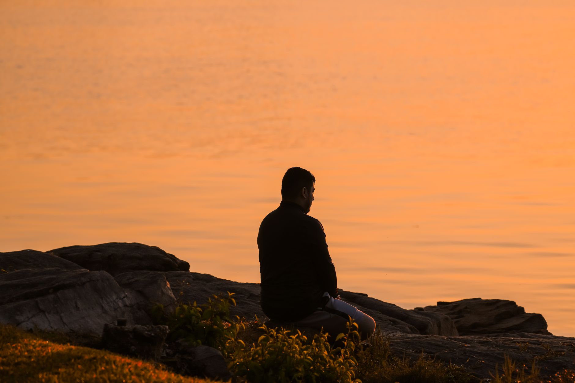 Person sitting alone in a calm, dimly lit room in quiet contemplation