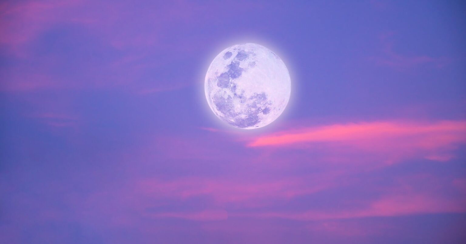 Large full moon glowing against a dark evening sky