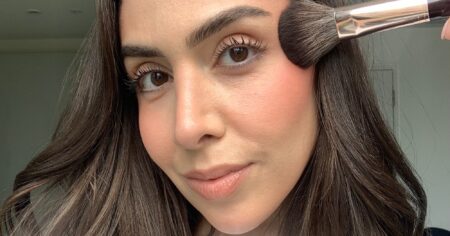 Blonzing Is What Happens When Bronzer and Blush Stop Fighting Close-up of a woman applying blush and bronzer to her cheeks with a makeup brush