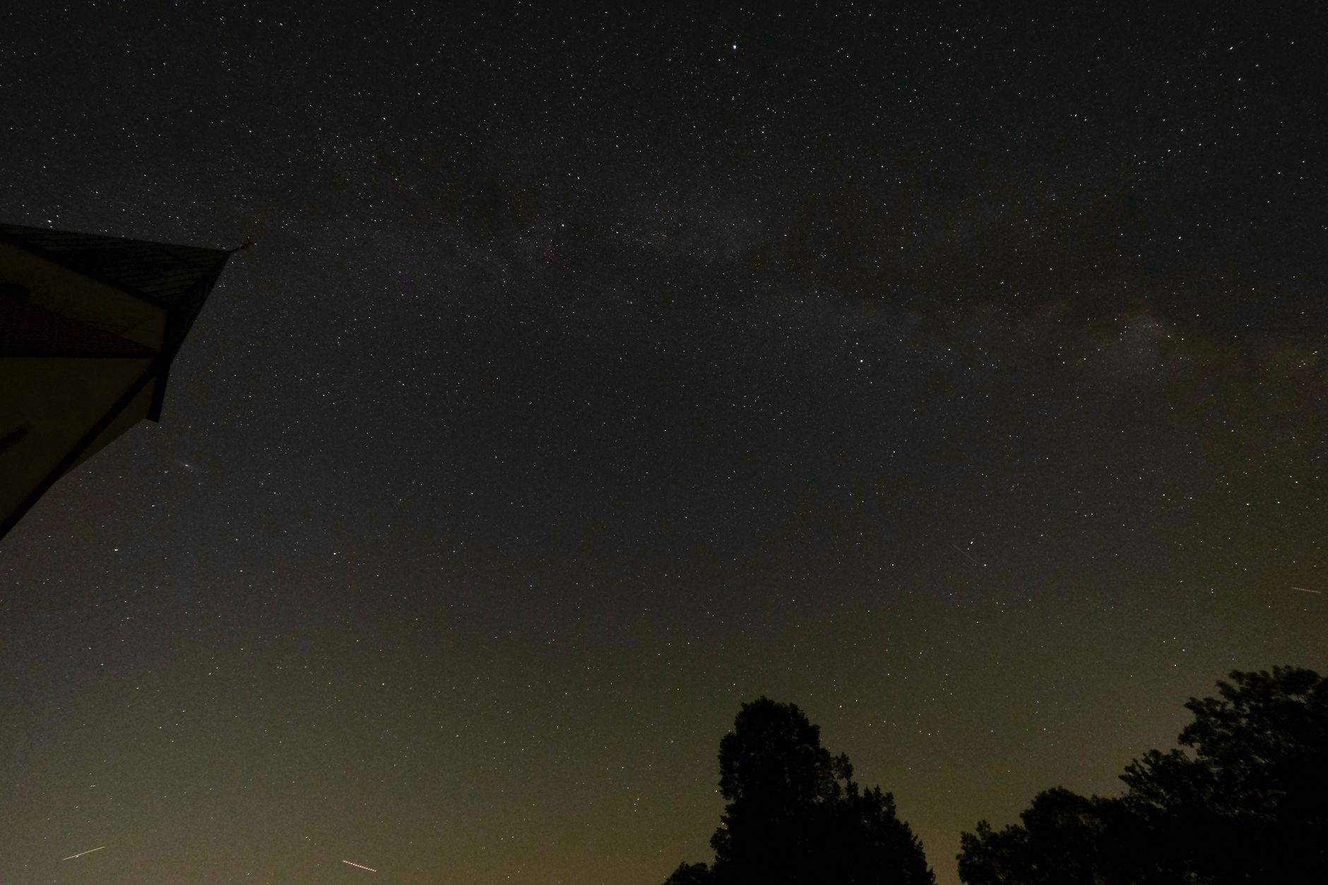 Star-filled night sky with visible constellations over an open landscape