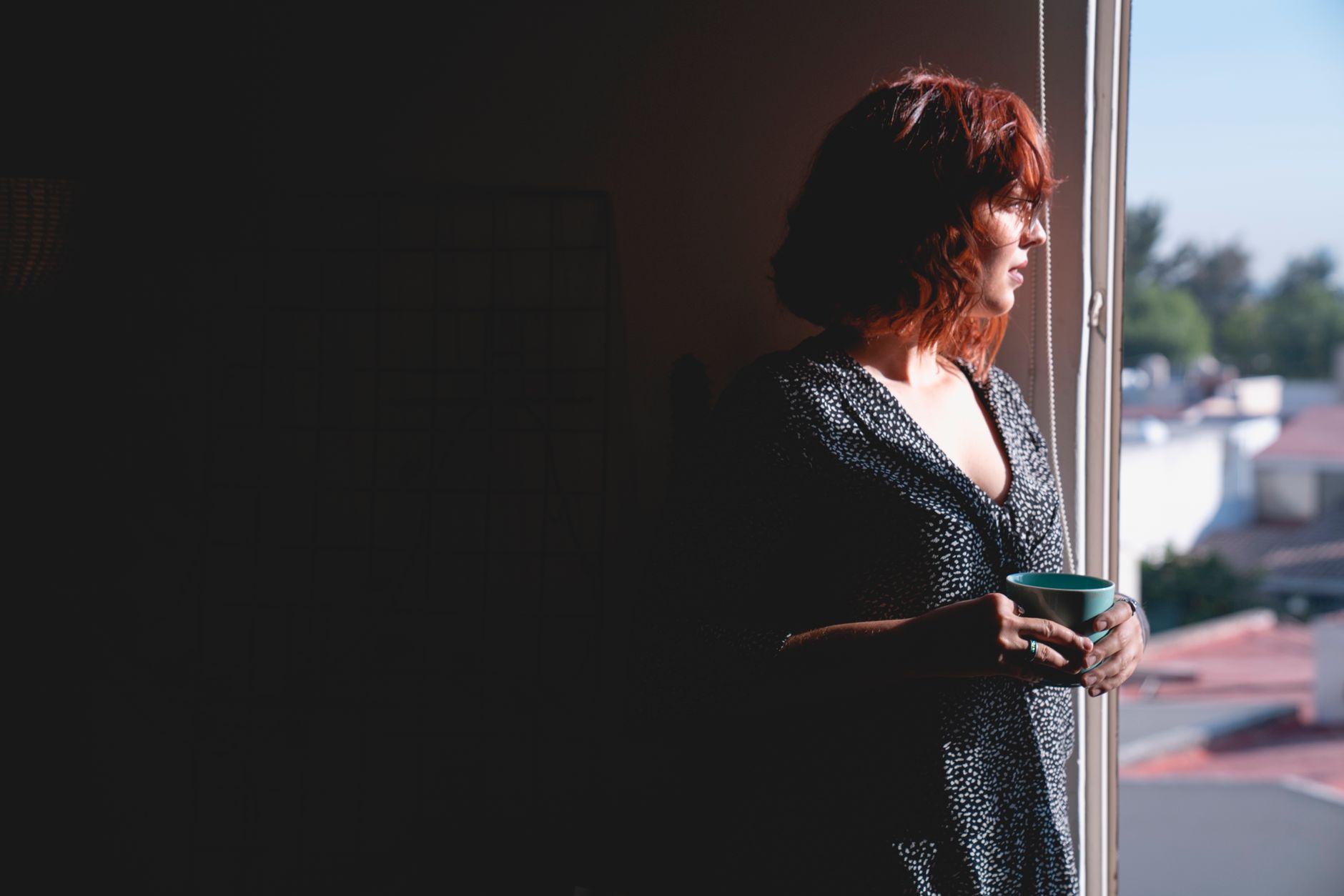Woman sitting alone by a window in quiet reflection