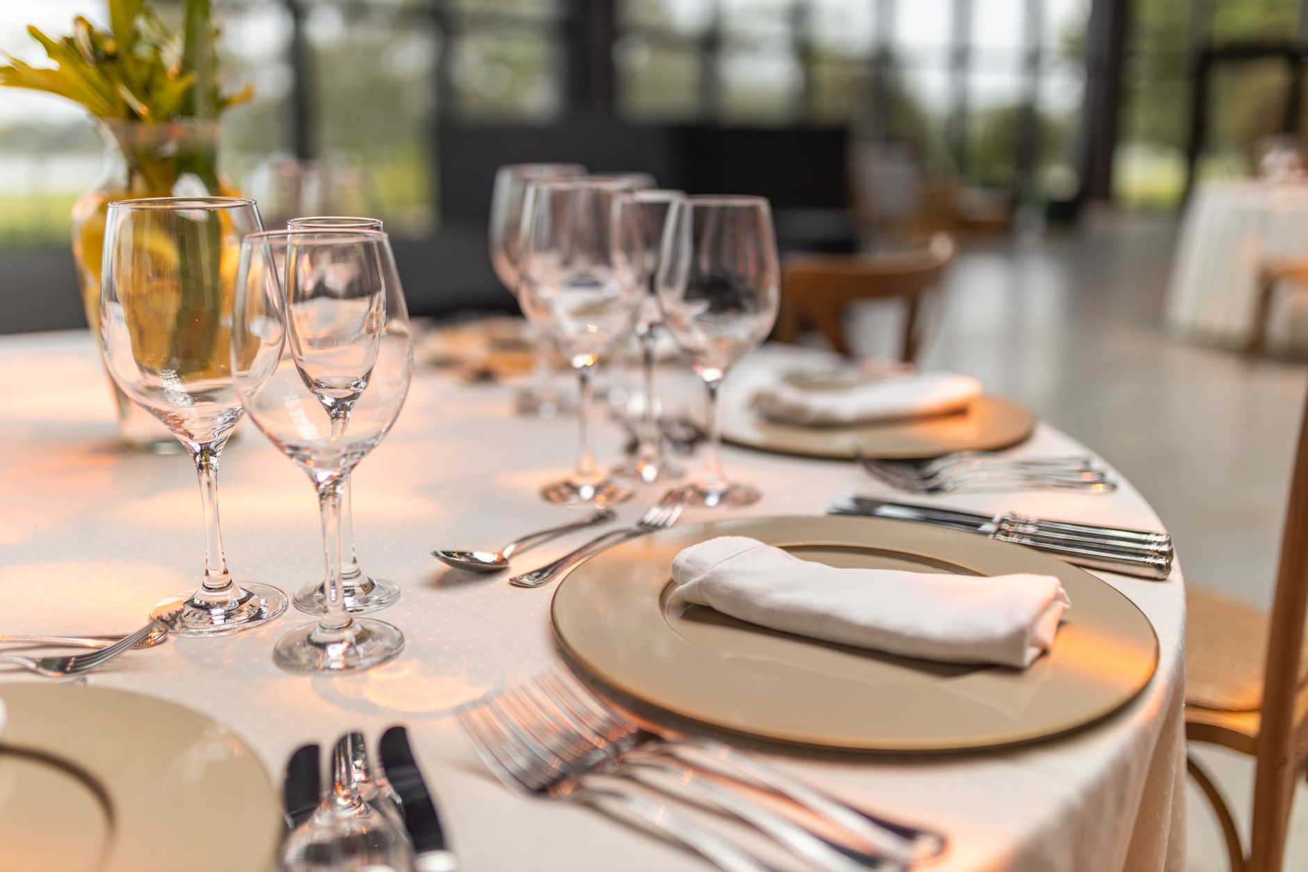 A beautifully set dinner table with warm lighting, flowers, and glassware