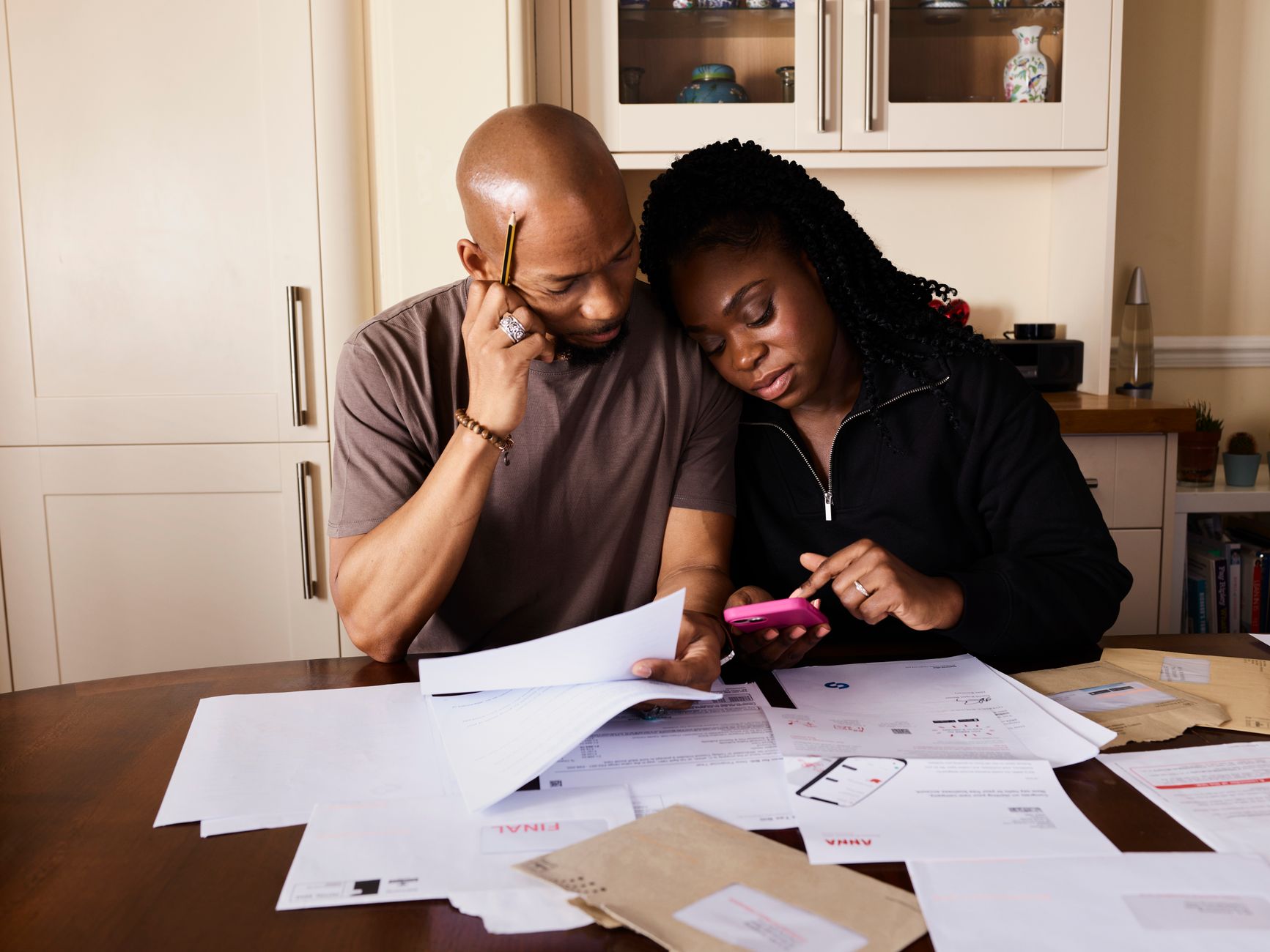 Two people sitting at a kitchen table reviewing finances together
