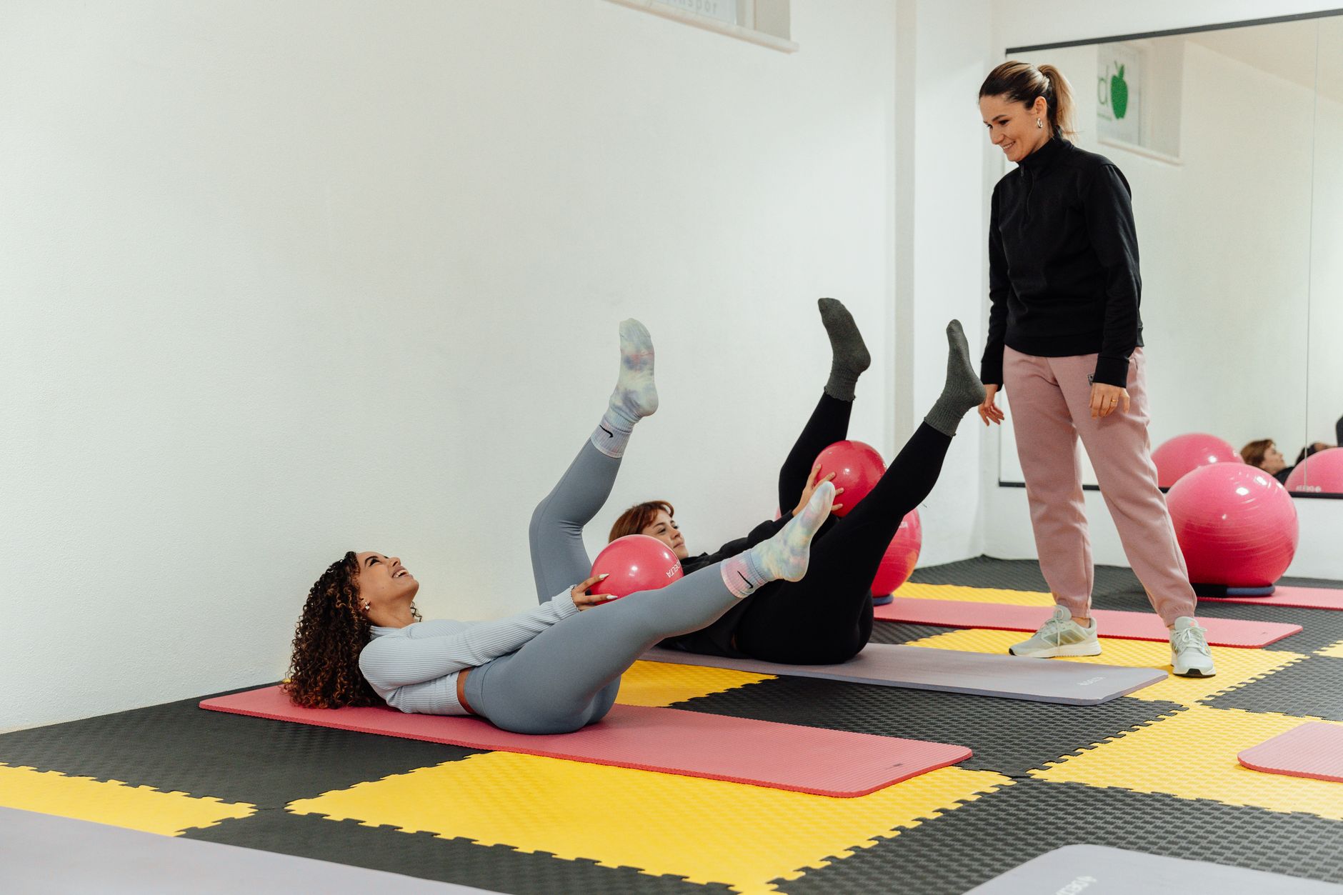 Person performing a Pilates exercise on a mat in a fitness studio