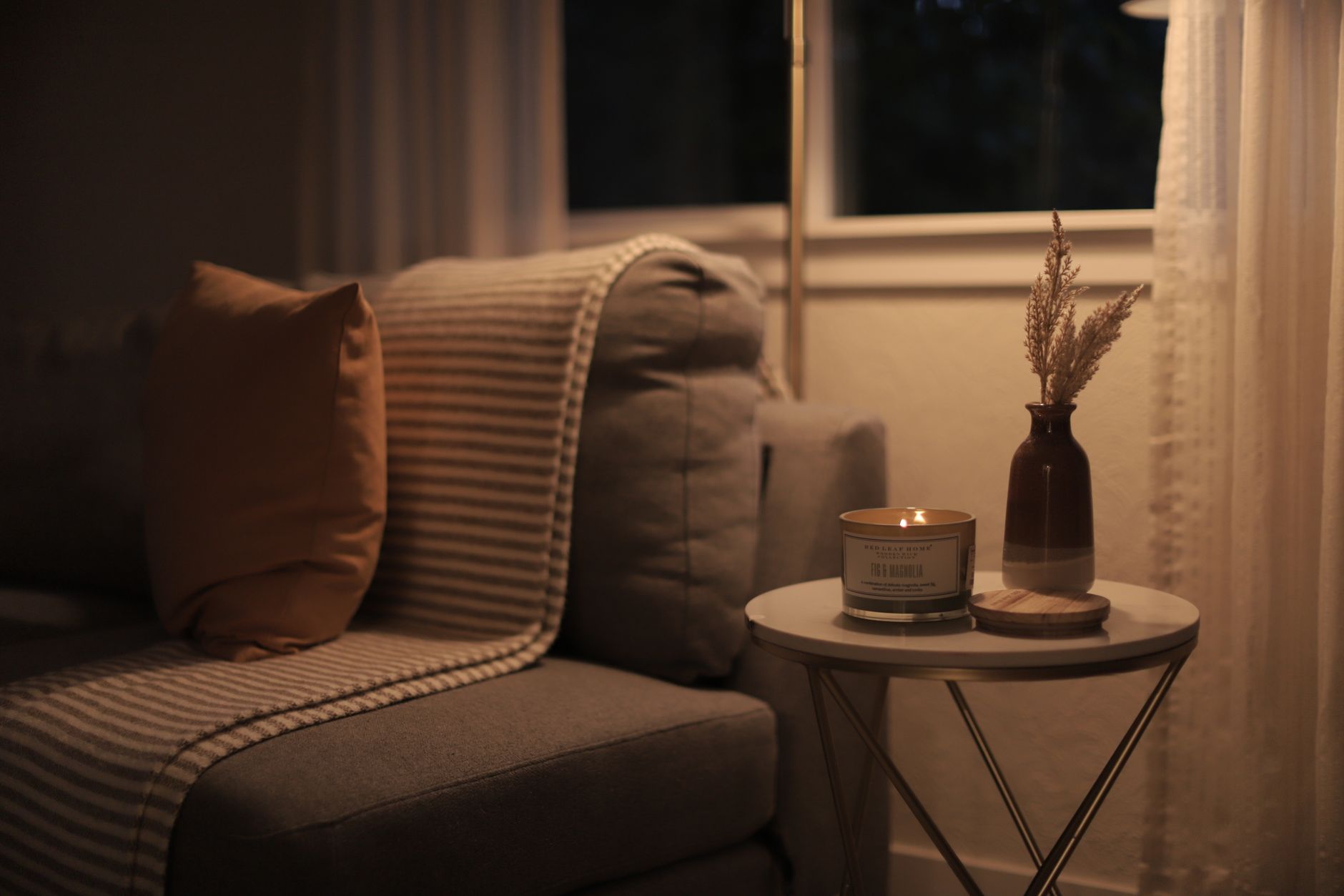 Warm candlelight glowing near a window at dusk, soft and contemplative