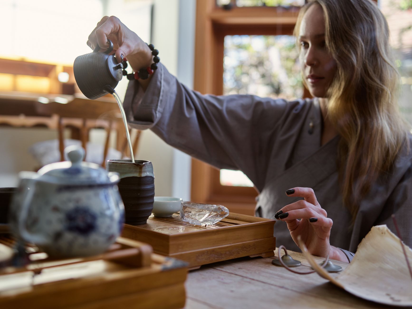 A person holding a warm mug at a sunlit window, in a calm morning setting